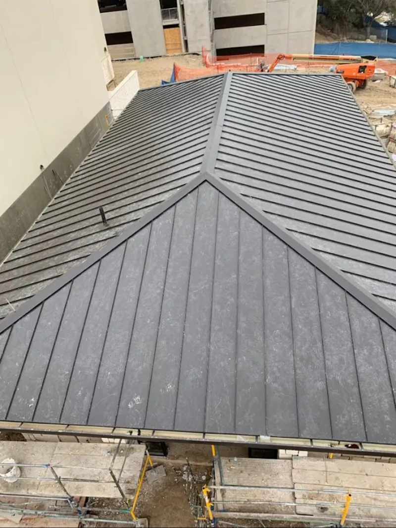 Commercial metal roof construction with crane equipment in Houlton